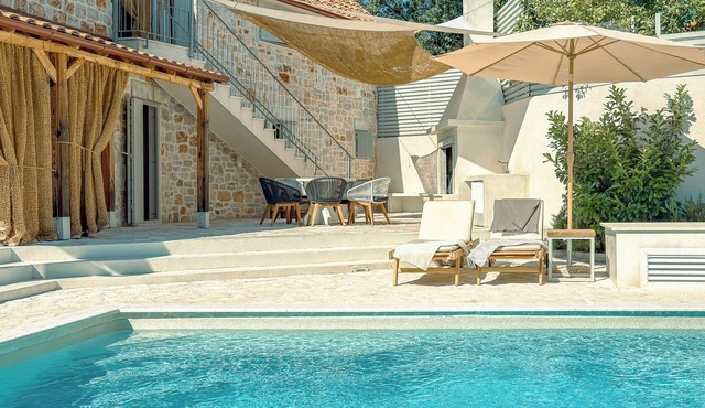 Modern expression of a traditional Hvar stone house amidst sunny nature.